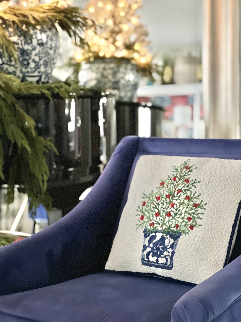 A blue chair with a Christmas pillow.