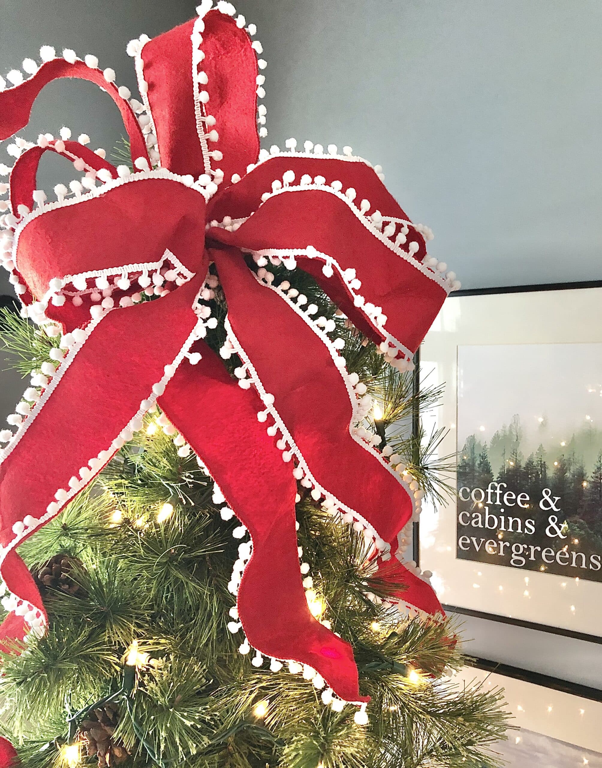 A large red ribbon tree topper gives a thin Christmas tree height and fullness.