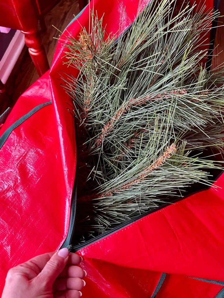 A Christmas tree stored in a red storage bag.