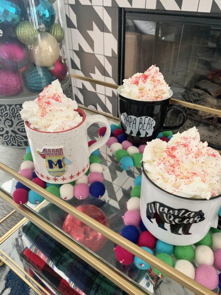 Three mugs of hot chocolate with whipped cream.