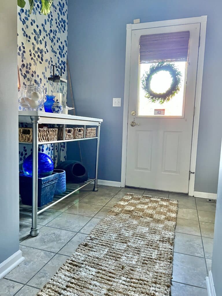 A checkerboard patterned jute rug runner in a mud room.