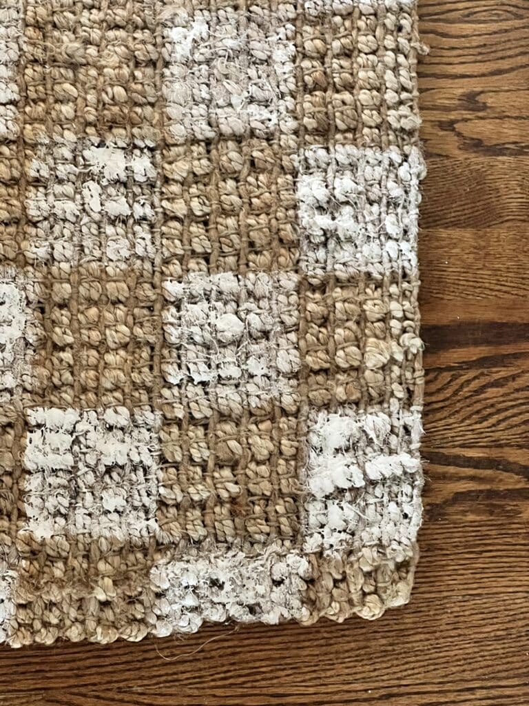 A close up view of a painted checkerboard jute rug.