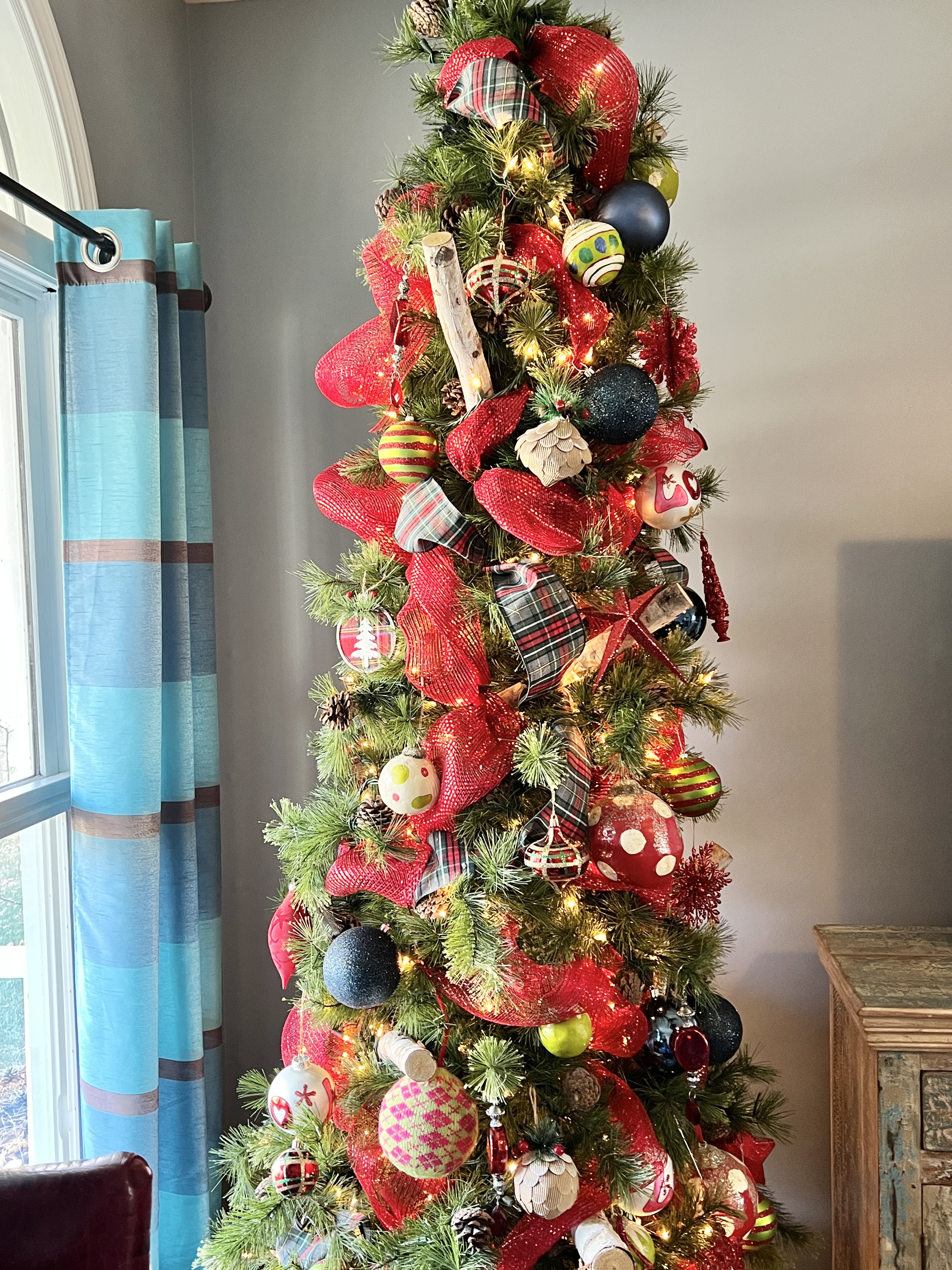 The Christmas tree filled with ribbon, ornaments, and lights.