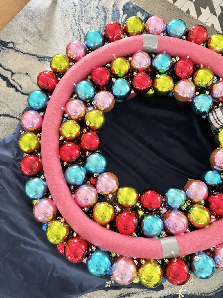 Christmas ornament wreath DIY: Three rows of balls attached to the circular pool noodles.