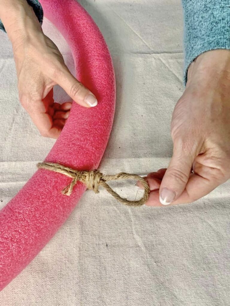 Christmas ornament wreath DIY: Adding jute covered wire as a hanger for the pool noodle ornament wreath.