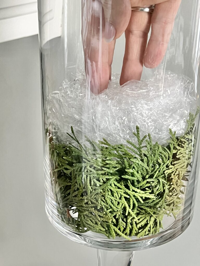 Crumpled plastic wrap layered on top of the the greenery.