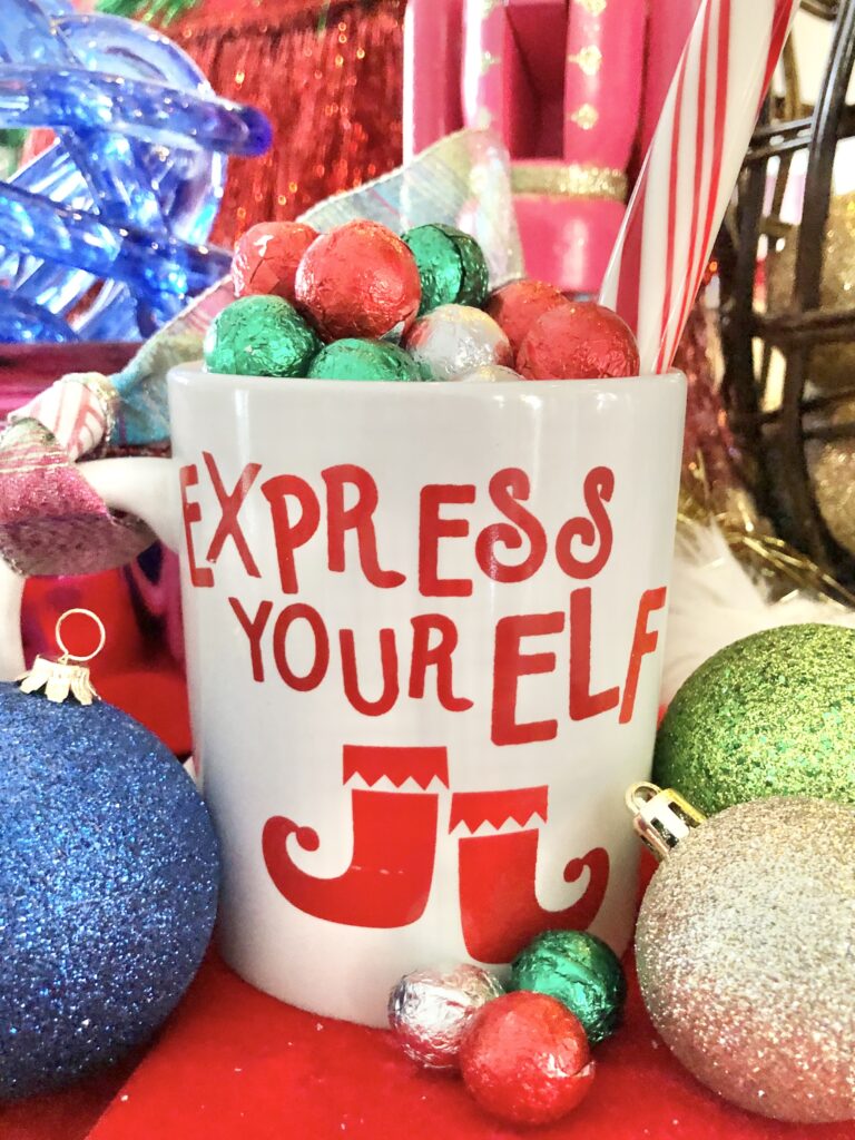 A red and white mug that says "Express Your Elf"