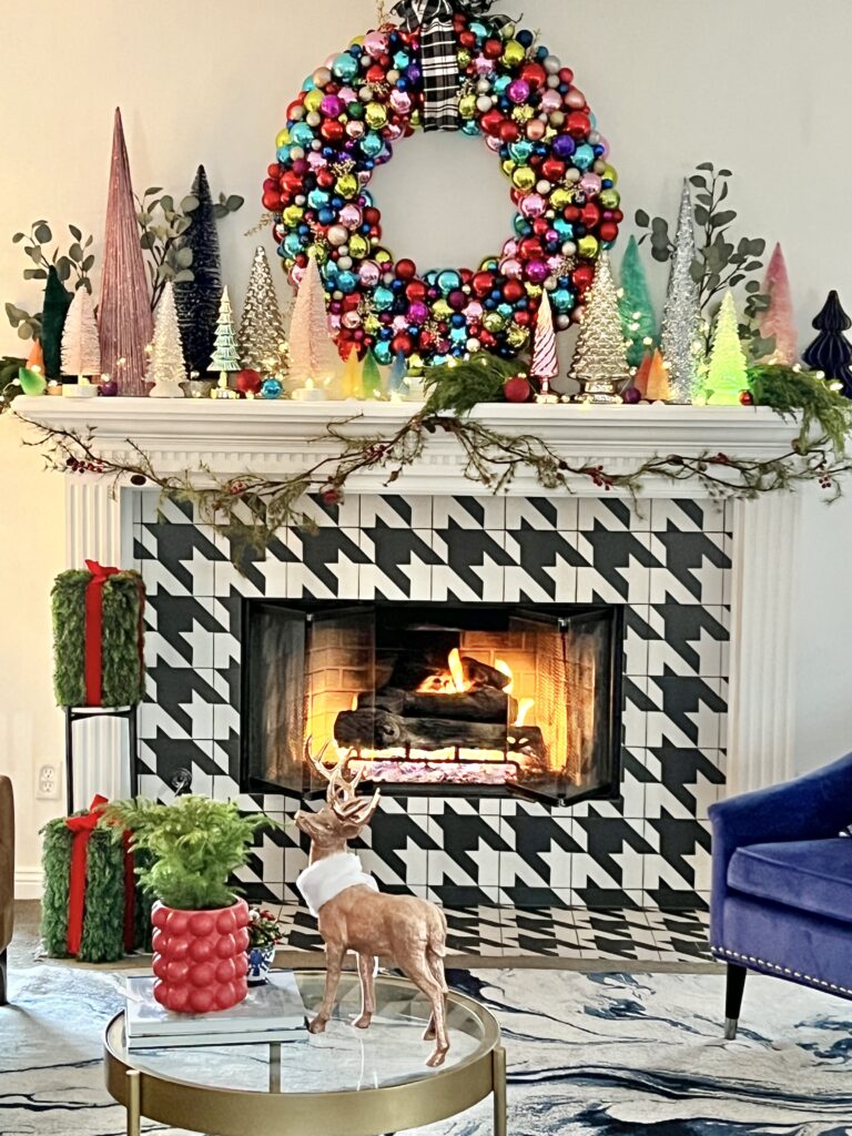 An ornament wreath made from pool noodles sits atop the fireplace.