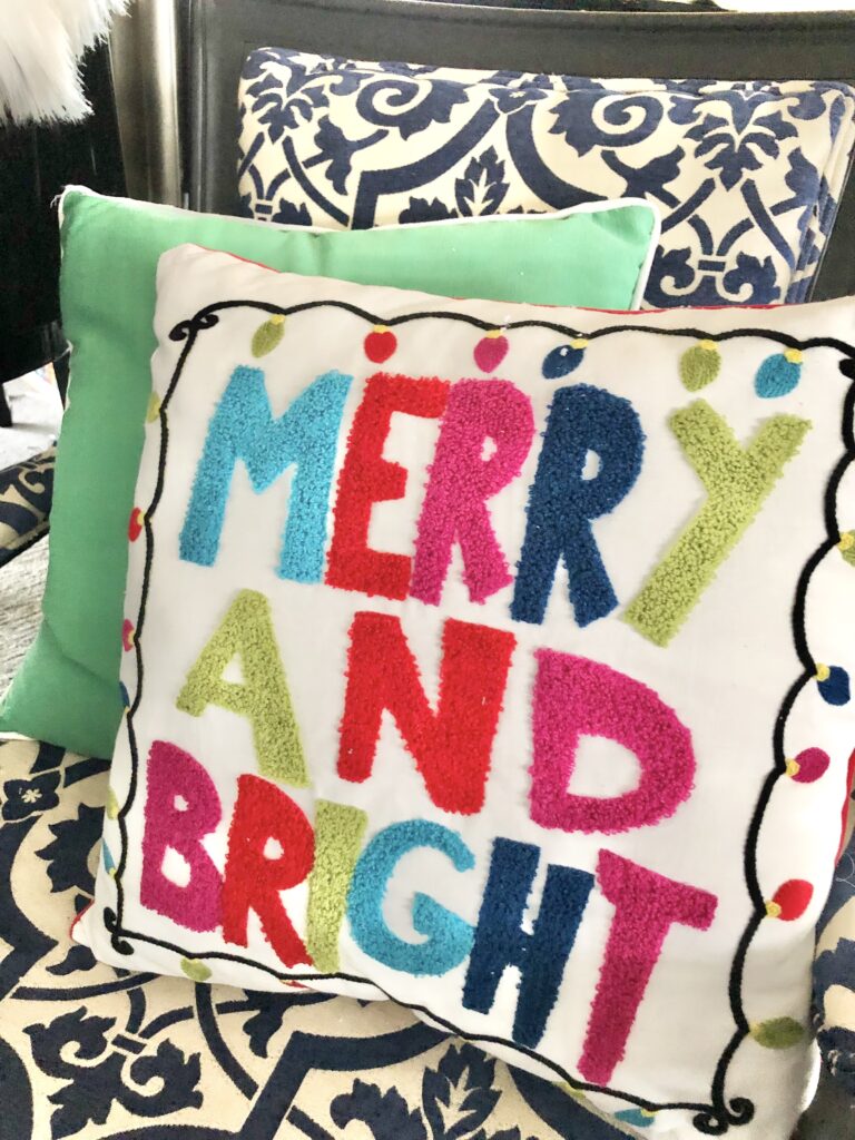 A Christmas pillow that says "Merry and Bright"