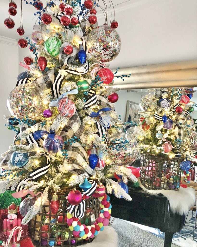 A colorful Christmas Tree placed in a basket on top of a piano.