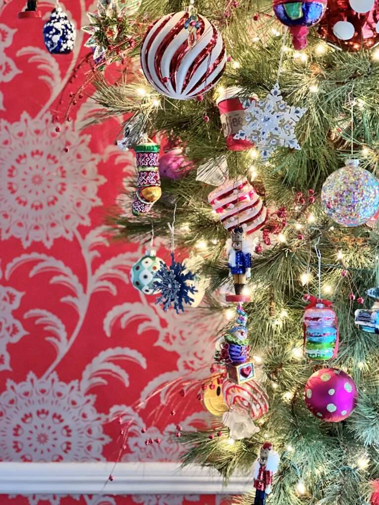 A variety of glass ornaments hanging from an upside down Christmas tree.