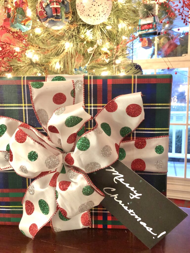 A polka dot bow on a plaid wrapped gift.