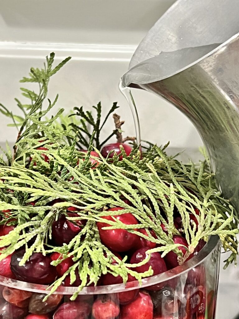 Pouring water on top of the Christmas centerpiece.