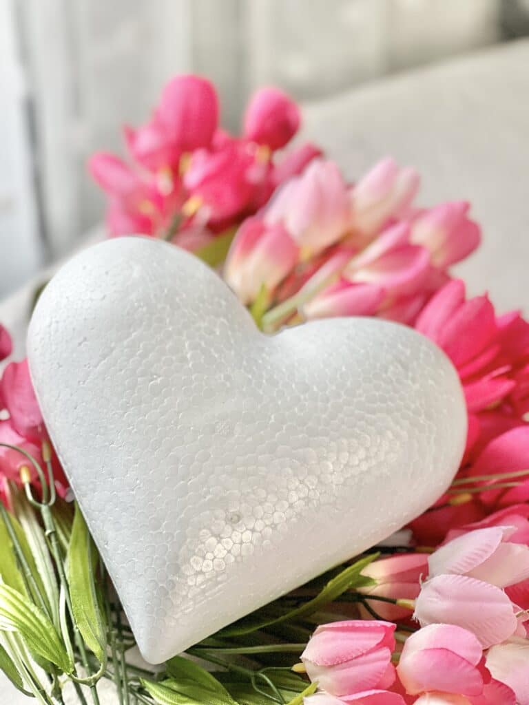 A dimensional foam heart and pink tulips that are the supplies for this Valentine's Day decor project.