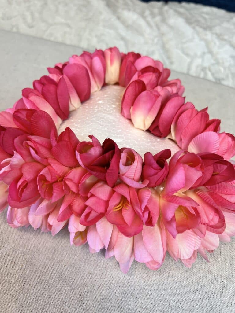 Valentine's Day decor taking shape as additional flowers are added to the foam heart.