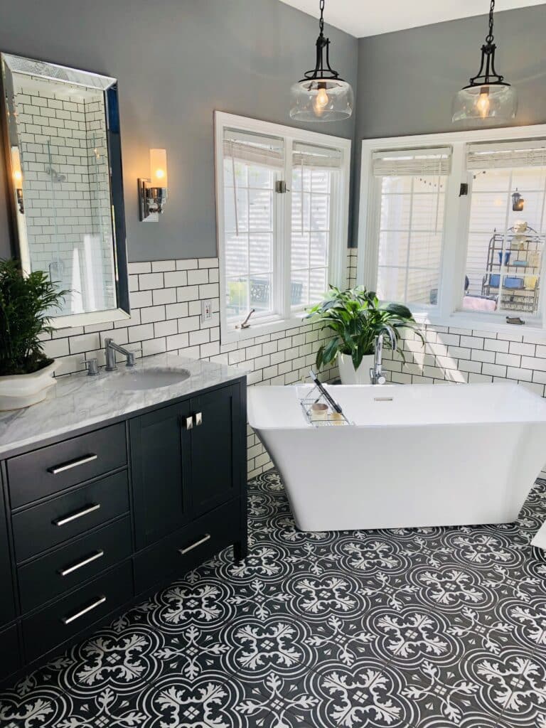 A bathroom renovated with black mosaic floor tile and white subway wall tiles.