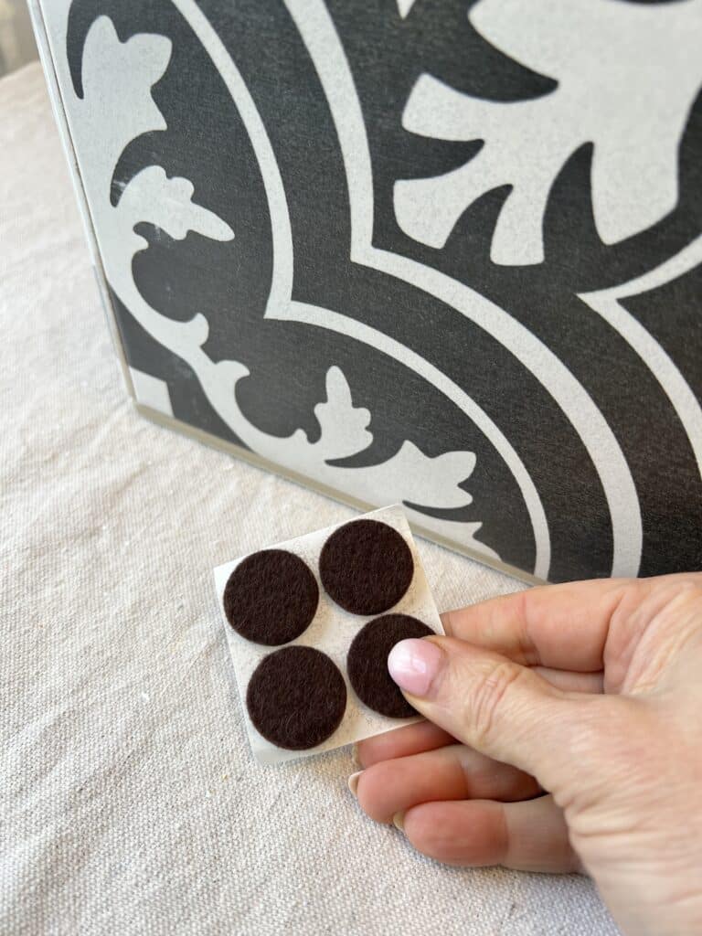 Adding felt furniture pads to the bottom of the DIY tile planter box.