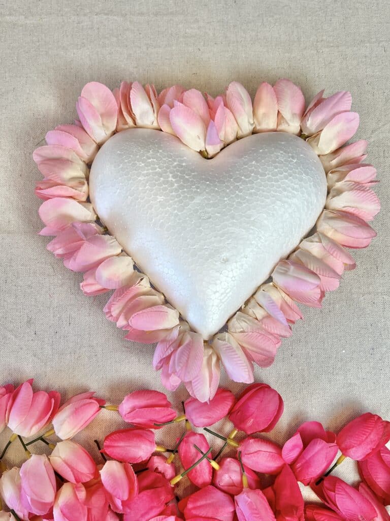 Pale pink tulip blooms insert into the perimeter of the foam heart to create Valentine's Day decor.