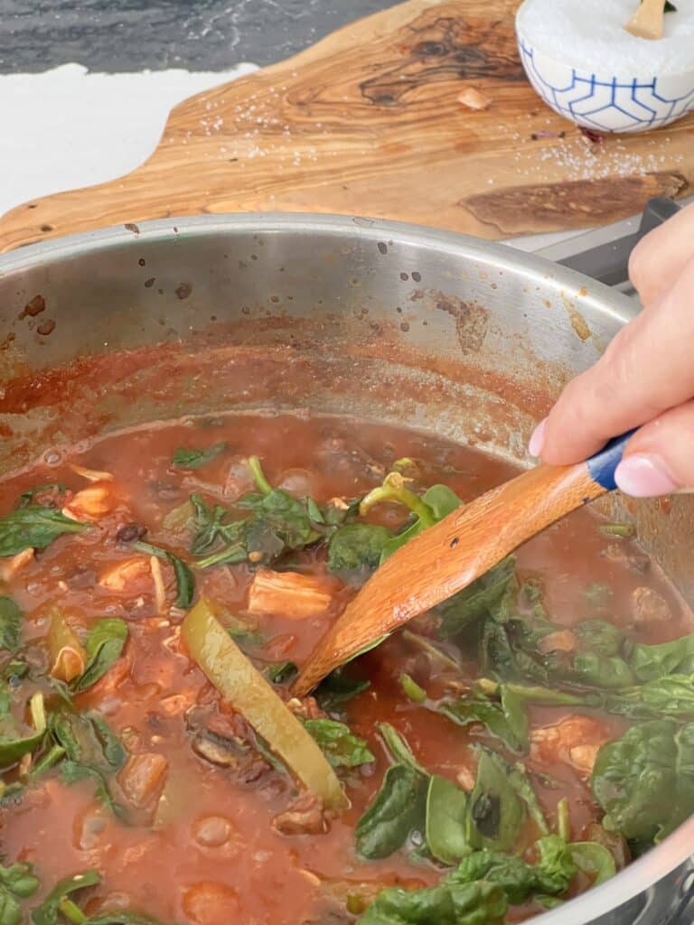 Stirring the pot of vegetable soup.