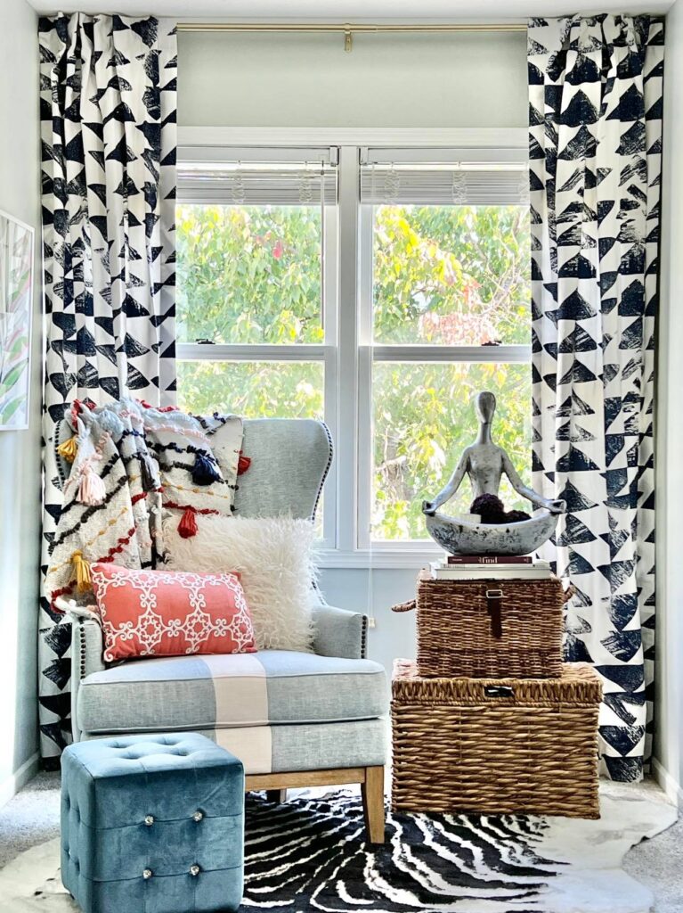 Blue and white patterned curtains hanging in a guest room.