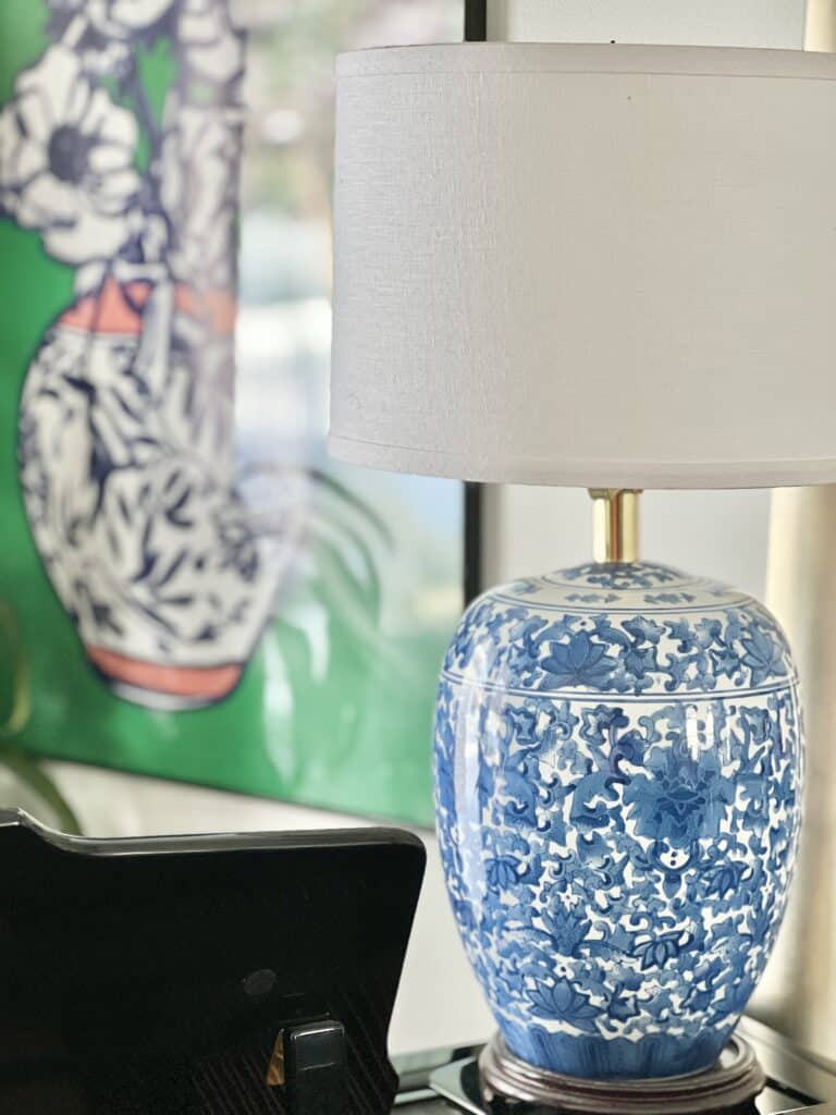A blue and white lamp sitting on a piano.