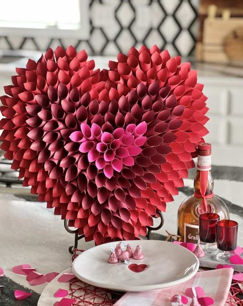 The paper cone Valentine heart displayed on an easel on a kitchen island.