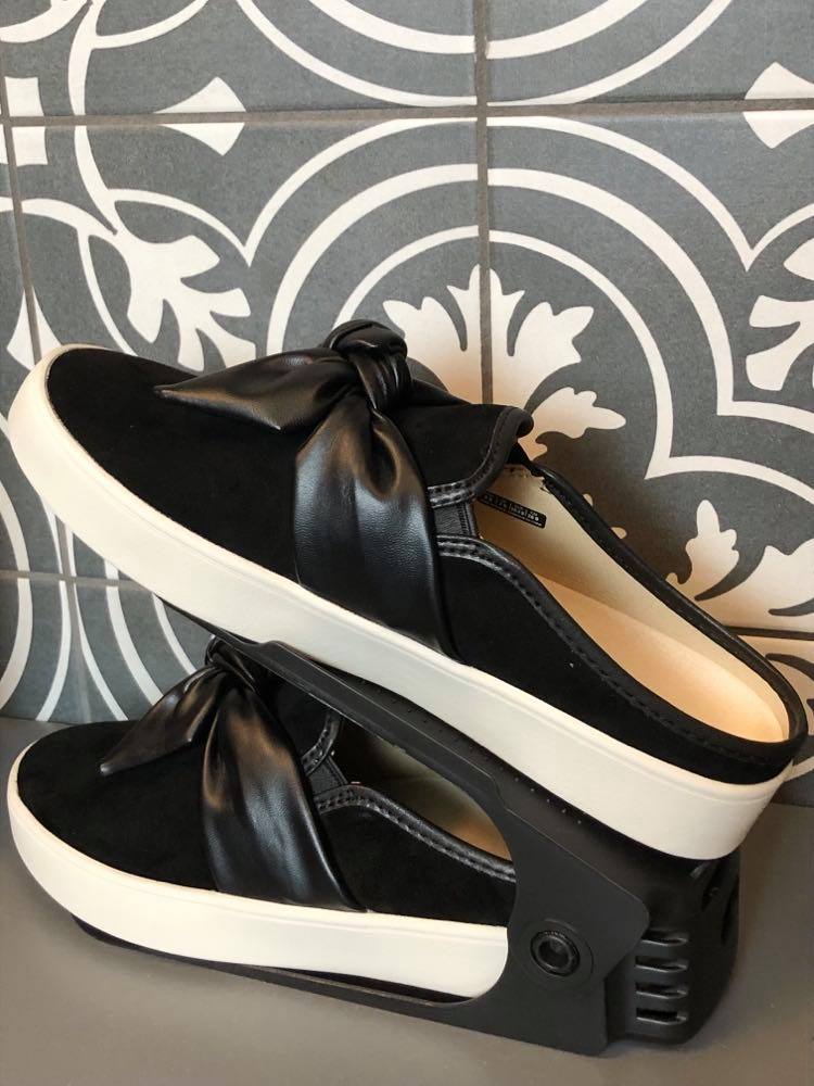 A pair of black slip-on shoes in a closet.