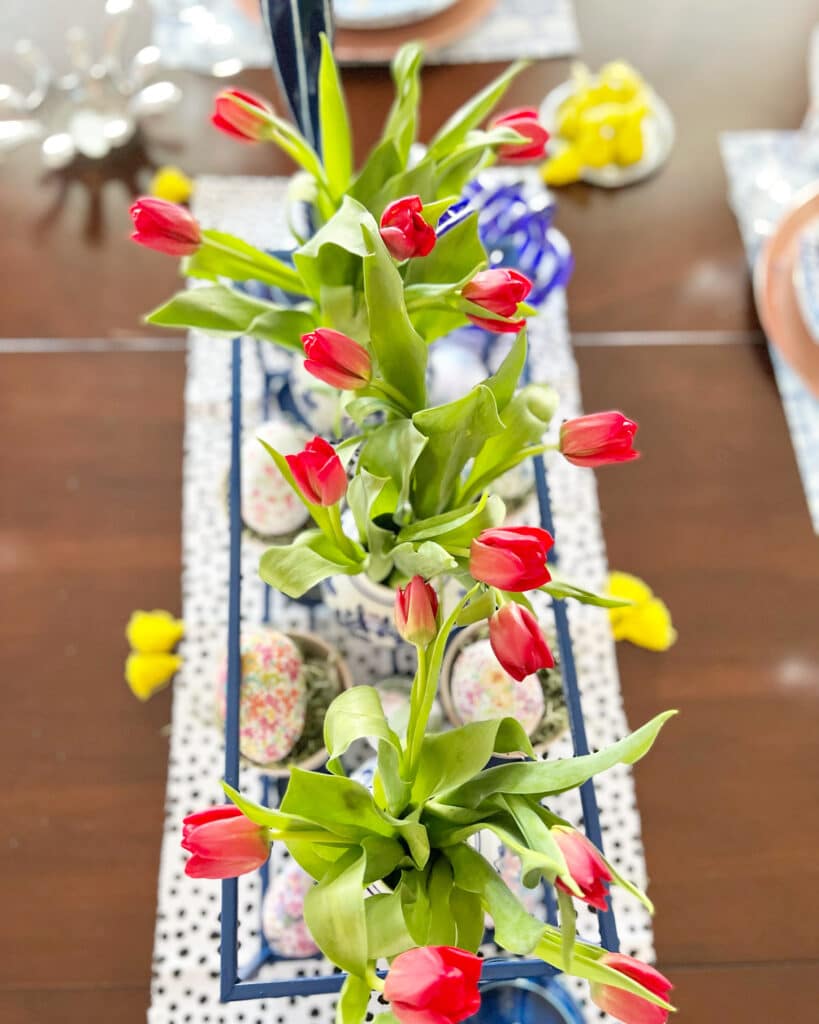Red tulips create colorful spring home decor when sitting on a table runner.