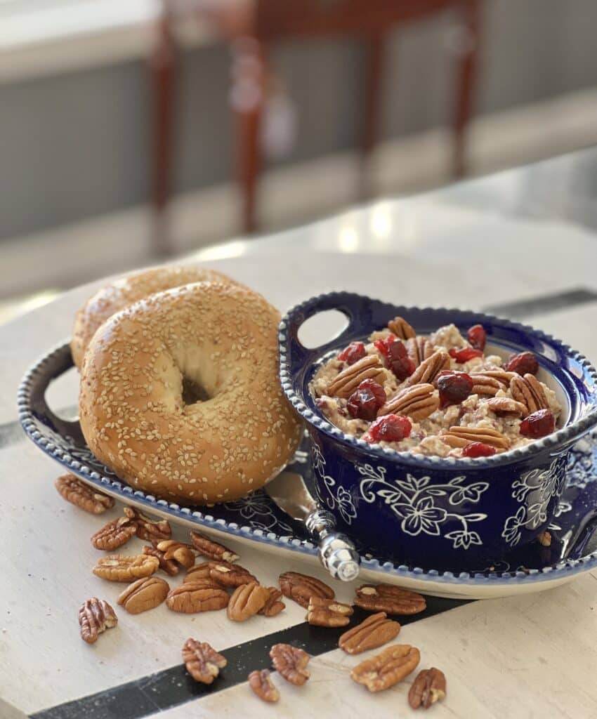 Two bagels and a dish of a Cranberry Pecan Bagel Spread.