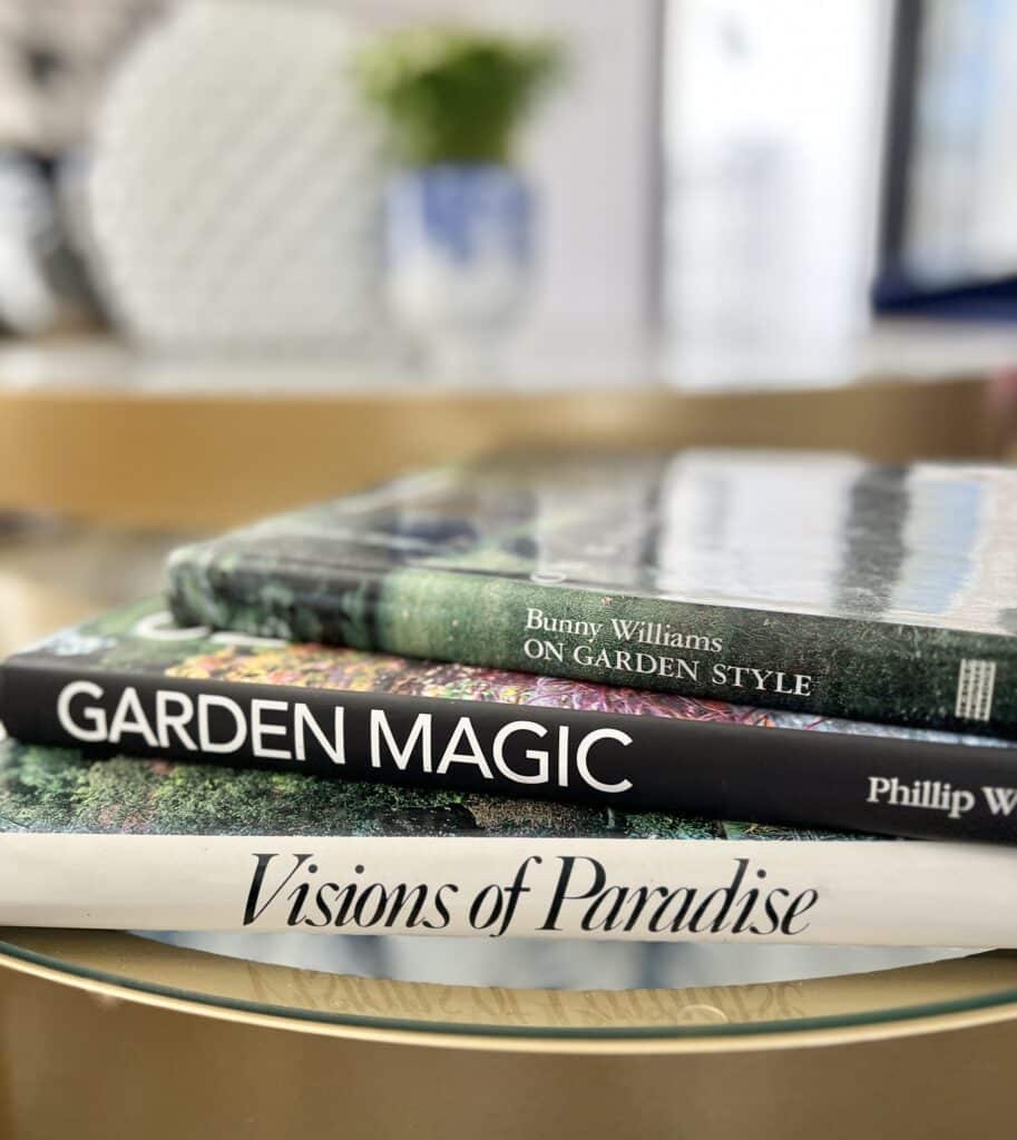 A stack of interior design books sitting on top of. glamorous gold coffee table.