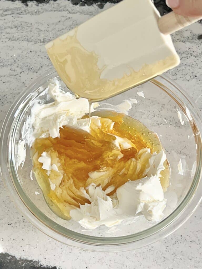 Combining cream cheese and honey.