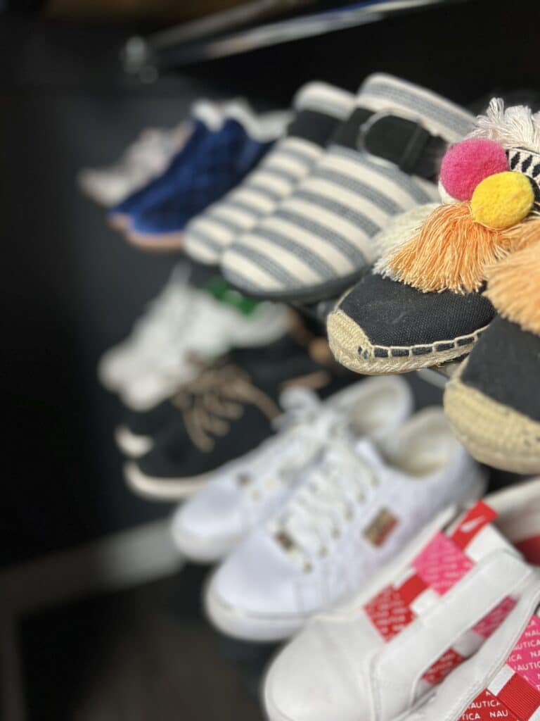 Rows of shoes being stored with diy tension rod shelving.