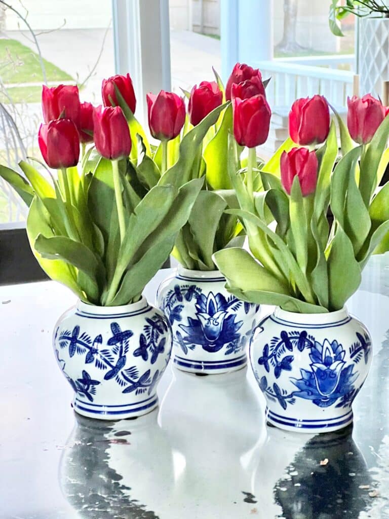 Blue and white vases filled with fresh red tulips.