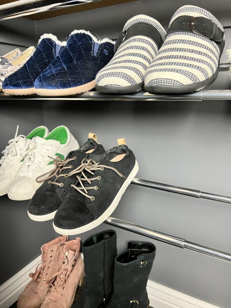 Two tension rods installed at an angle for shoe storage.
