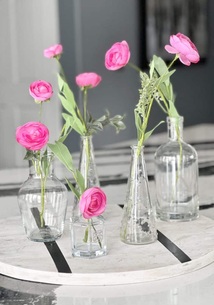 Pink blooms in glass bud vases creates a centerpiece decoration for spring.