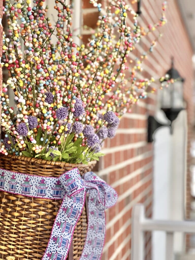 A hanging basket full of faux florals and stems for diy glass door insert.