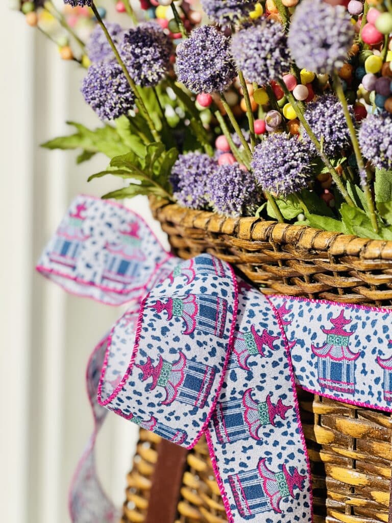 Purple and pink faux flowers in a front door basket is a great spring decor idea.