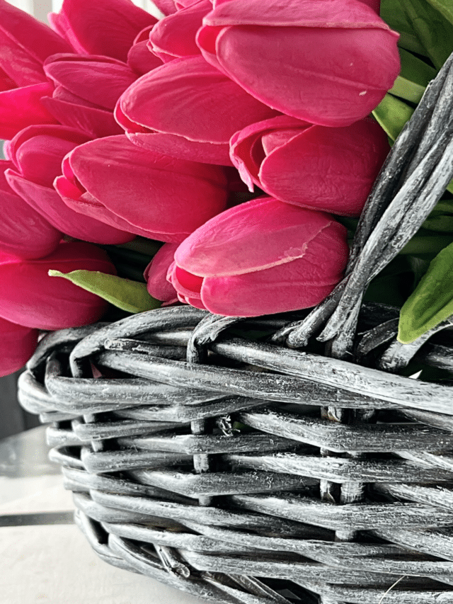 A painted wicker basket filled with pink tulips.