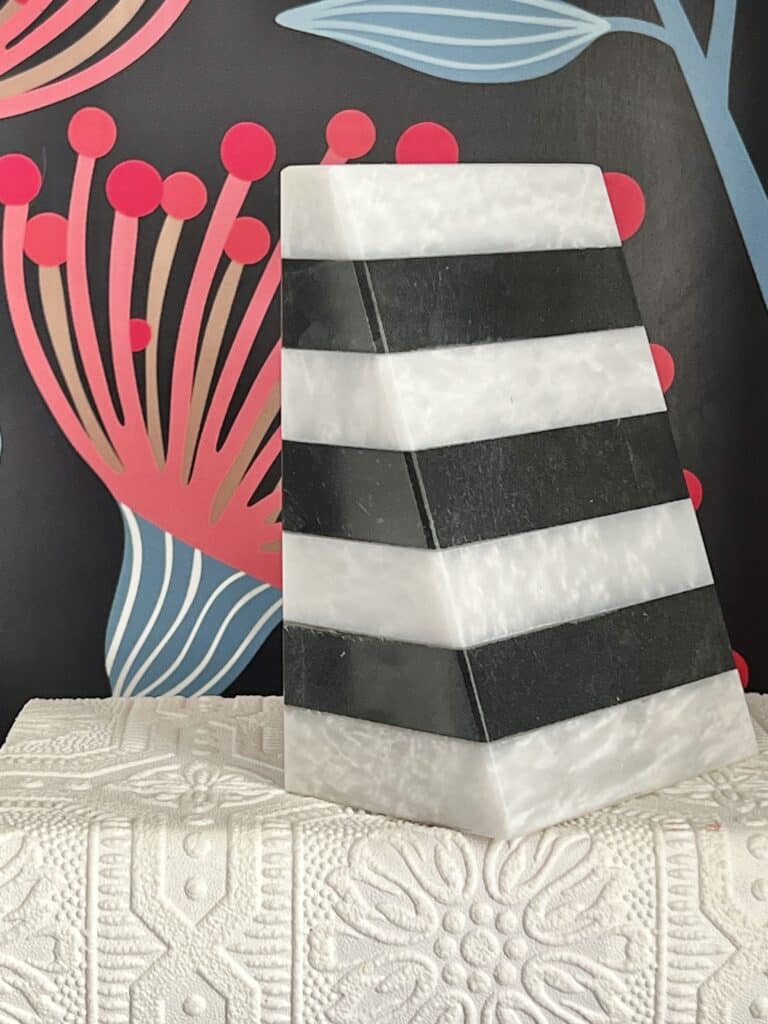 A black and white marble bookend sits on a white book.