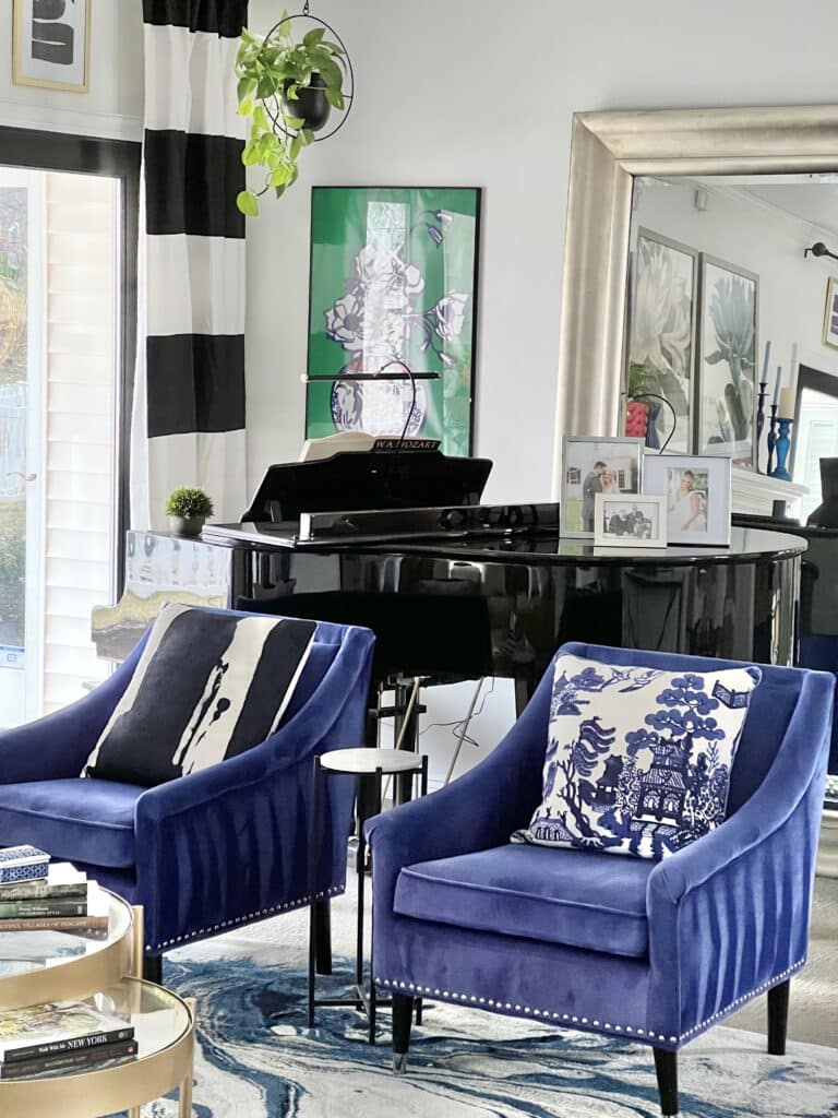 Two blue chairs sitting in front of a baby grand piano.