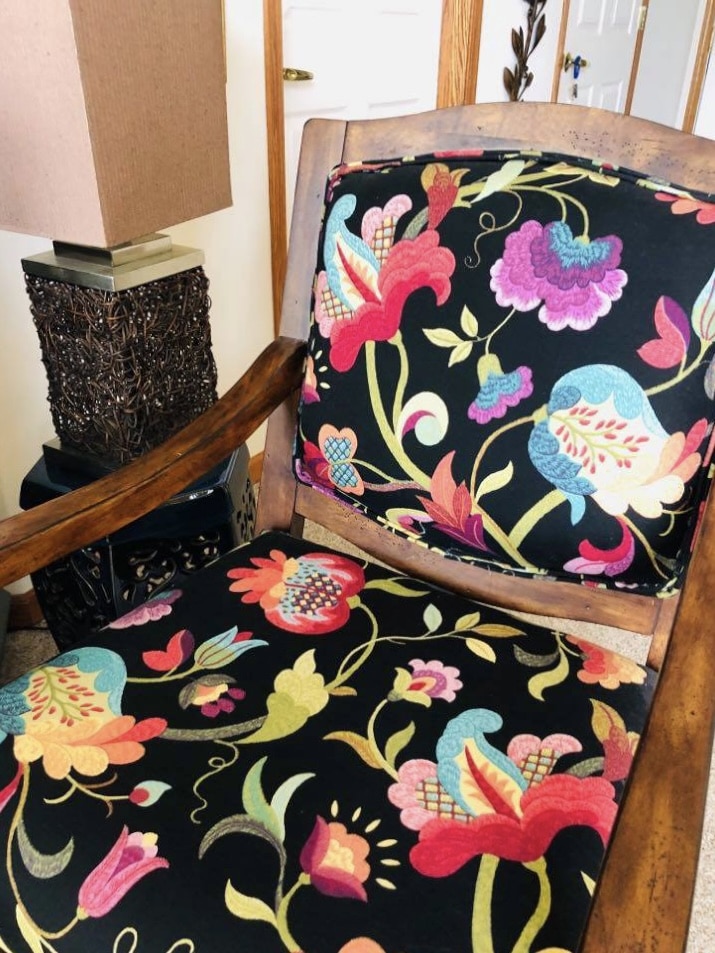 A reupholstered chair with fabric in red, blue, purple, citron, and black.