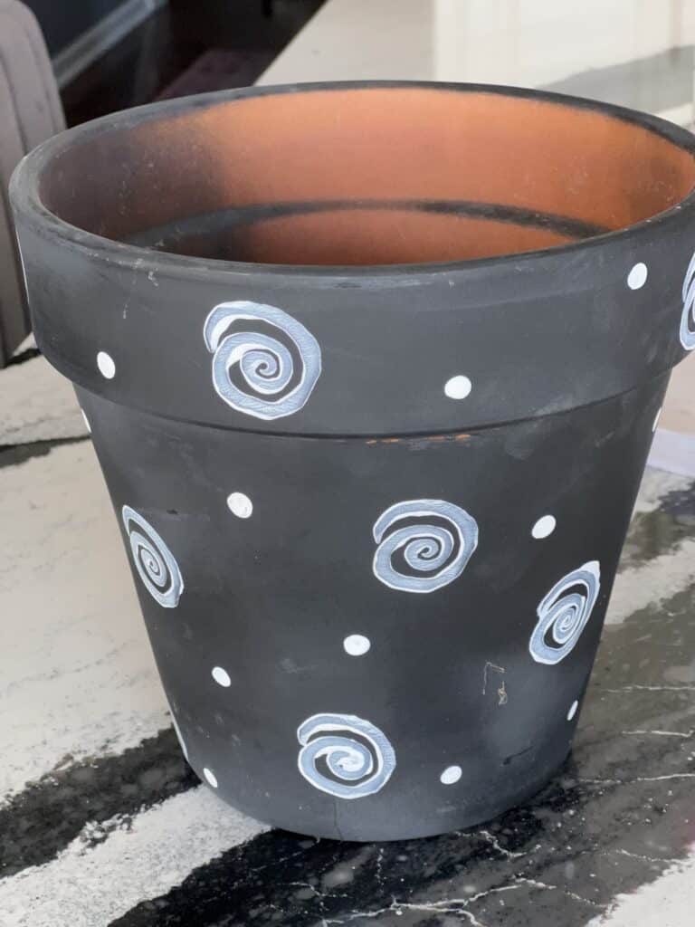 An old terra cotta flower pot that was painted black many years ago.