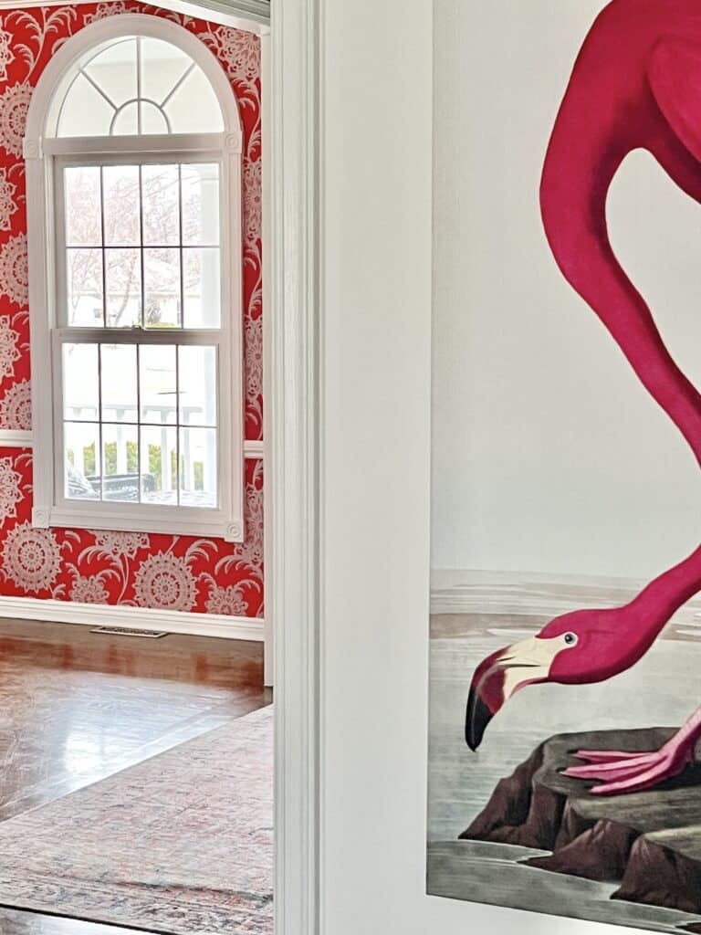 A pink flamingo canvas hangs from a white wall.