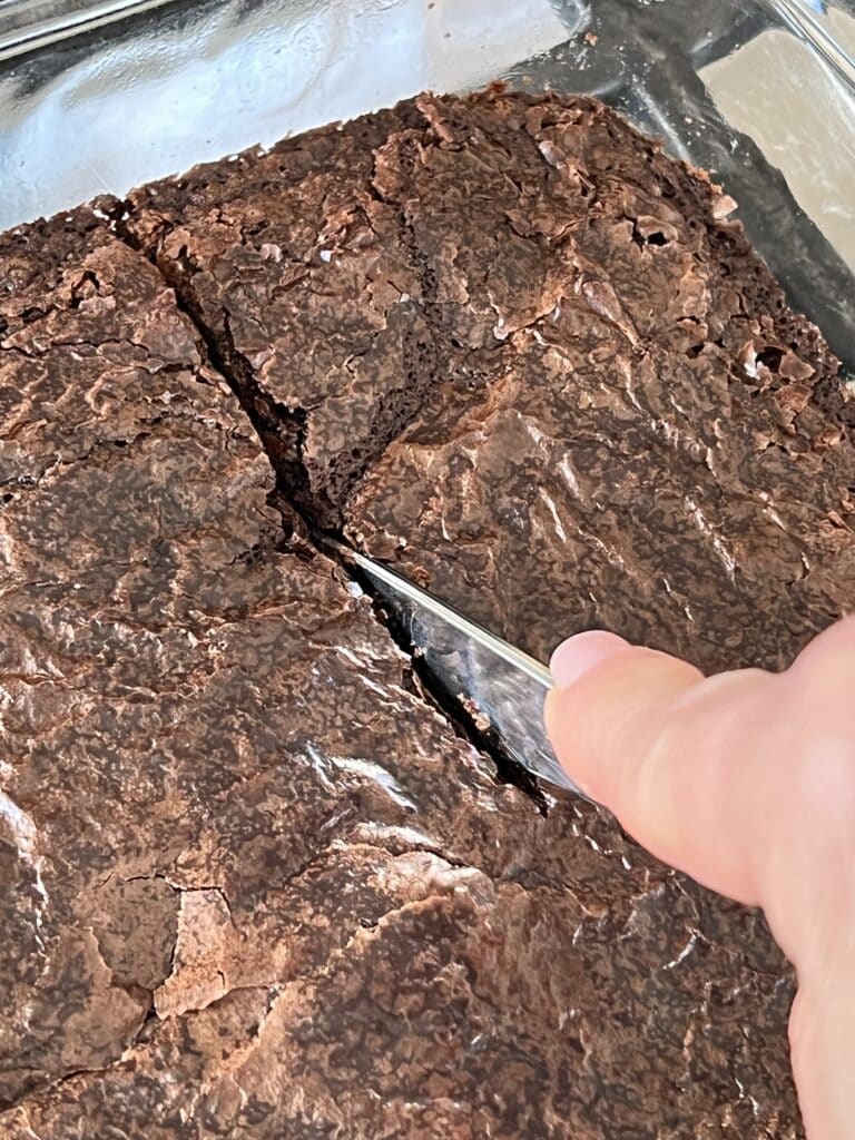 Cutting the Symphony brownies into large squares for serving.