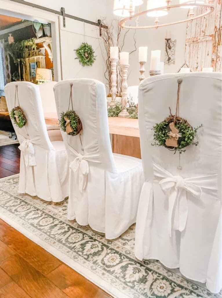 Charming bunny wreaths decorate that back of dining chairs for Easter.