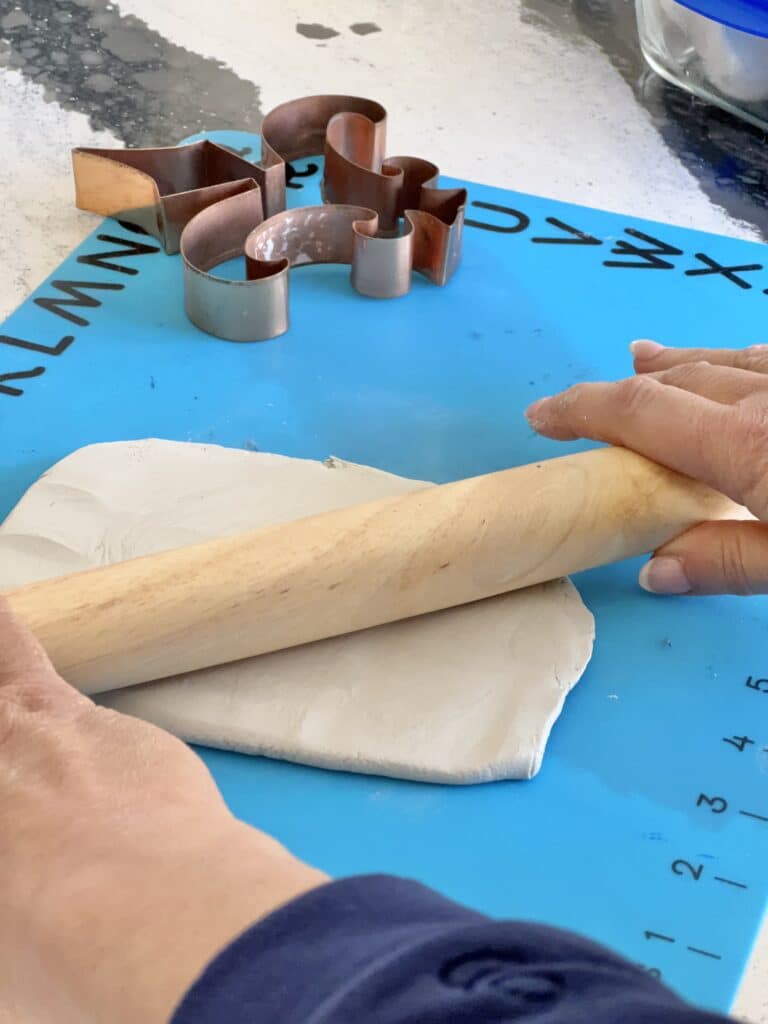 Rolling out the air dry clay with a rolling pin.
