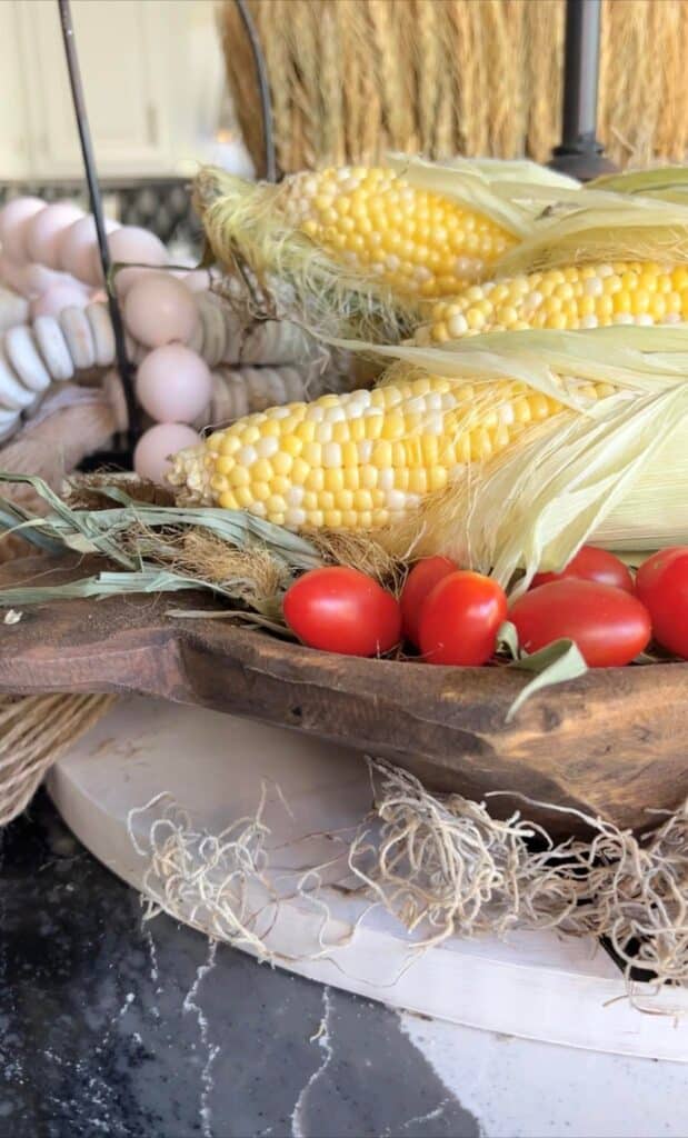 Yellow corn and cheery tomatoes in a douogh bowl on a kitchen table.