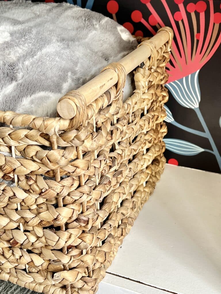 A basket full of fluffy throw blankets serves a great storage on the bottom shelf of the bookcase.