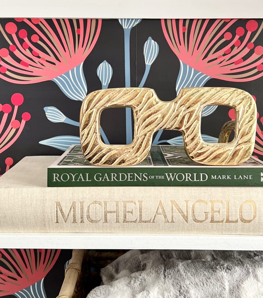 Whimsical gold glasses sit on top of a stack of books as a unique home accent.