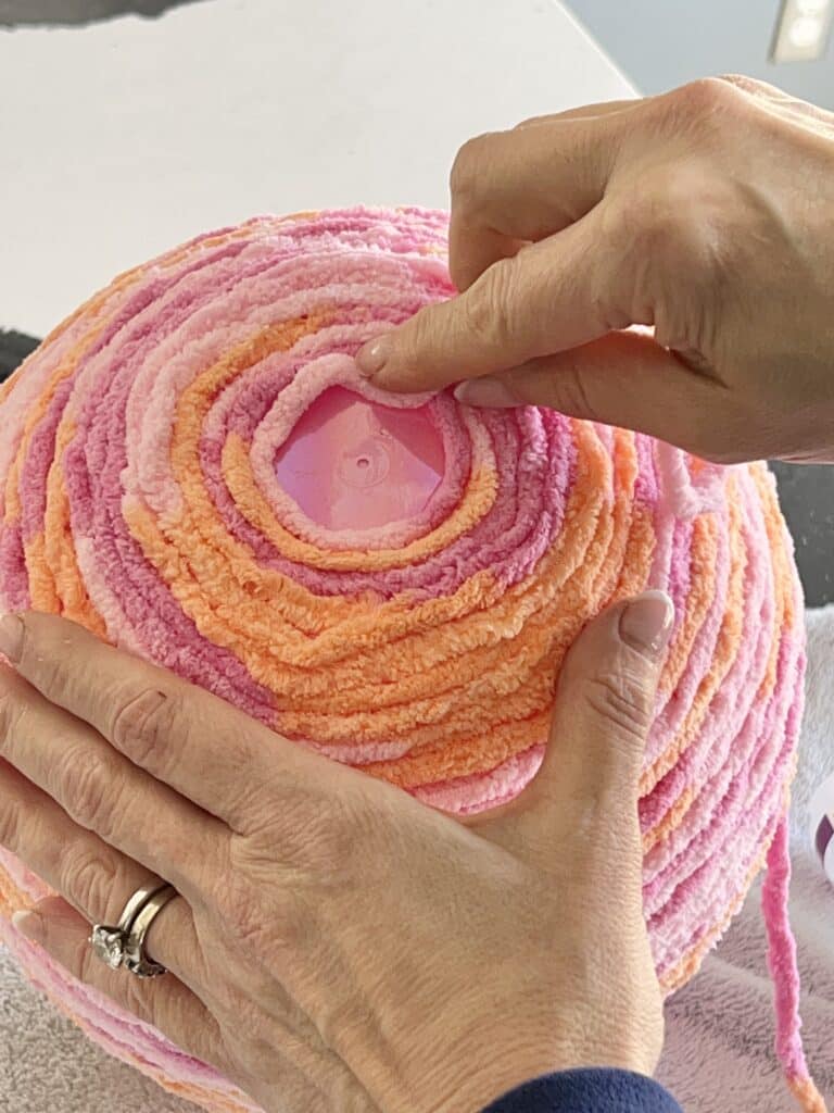 Completing the winding and glueing process at the bottom of the yarn wrapped egg.